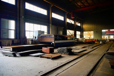 Çelik yapı atölyesindeki yay şekilli bileşenler ayrılmıştır ve kavisli çelik plakalar kubbeler ve kemerli köprüler gibi özel şekilli çelik yapıların çekirdek hammaddeleridir..