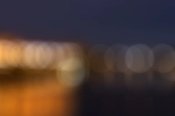 Modern arka arka plan bulanık yuvarlak nesnelerle. Altın ve mavi bokeh odak dışında olduğunu cityscape üzerinden.
