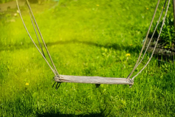 Stary huśtawka na linach na zielonym tle trawnika — Zdjęcie stockowe