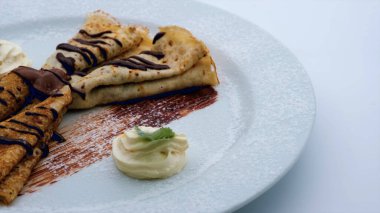 Fresh pancakes poured with chocolate for breakfast