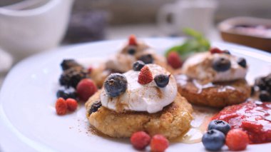 Hot cheesecakes with berries and honey for breakfast