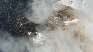 Flying above the clouds on a drone with a view of the forest