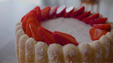 Çilek dilimlerini pastanın üzerine serptik.