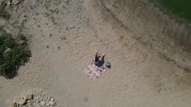 Güzel Drone Deniz sahilinde kumdaki küçük bir kızın daire çizen videosu