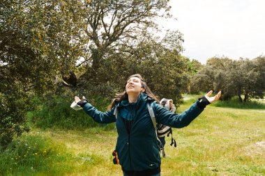 Doğada kollarını açıp doğayı hisseden bir kadın. Özgürlük, macera ve açık hava tatillerinde yaşam tarzı kavramı.