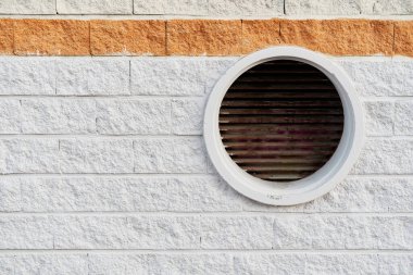 Sağ tarafında dairesel hava çıkışı olan gri ve kırmızı renkli sert beton duvar. Mimarlık ve tasarım konsepti.