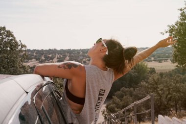 Bir yolculukta arabanın camında oturan bir kadının dikiz görüntüsü. Seyahat konsepti ve yaşam tarzı