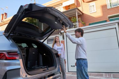 Genç çift bagajlarını bavullarla dolduruyor, uzun bir yolculuğa hazırlanıyorlar. Gülümsüyorlar, seyahat macerasına hazırlar.