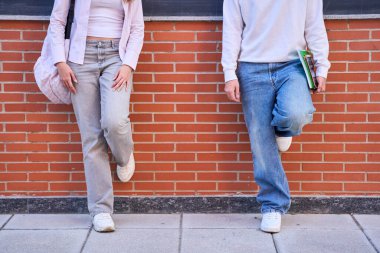 Öğrenciler, kampüsteki tuğla duvar boyunca aralıklarla uzaklaşıp sosyal mesafeyi ve yeni normal etkileşimi denediler.