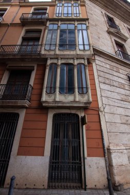 Valencia 'nın eski bir kasabası olan Valencia' da geleneksel Akdeniz mimarisini sergileyen süslü süslü balkon, işlenmiş demir pencereler ve desenli taş duvarlarla tarihi Valencia cephesi..