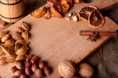 Çeşit çeşit fındık, tohum ve kurutulmuş meyve. Anason ve tarçın, notlar için yeri olan tahta bir tahtaya yapışmış..