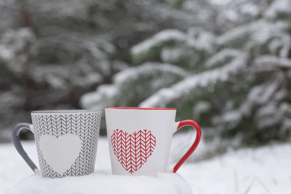 Deux Tasses Avec Des Coeurs Sur Neige Sur Fond Pins — Photo