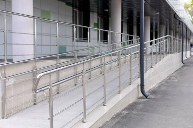 Hastanenin girişinde metal tırabzan olan bir rampa.