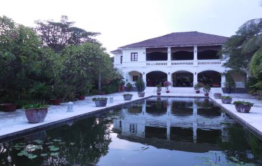 Mui ne, Vietnam, Allezboo Beach Resort, 24 Ekim 2016. Bir bahçe ve su zambaklarıyla dolu büyük bir süs havuzu suya yansıyan güzel bir binanın önünde..