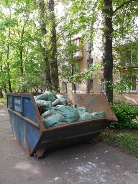 Moskova, Rusya, Mayıs 2021. Büyük ölçekli inşaat atıklarını toplamak ve kaldırmak için büyük metal bir sığınak, büyük onarımların devam ettiği bir apartmanın yanında yer alıyor..