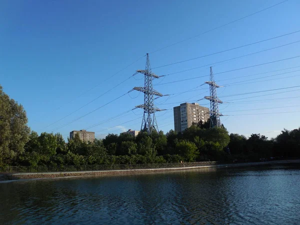 2021年6月 俄罗斯莫斯科 Mkad附近的娱乐区 在蓝天和蓝树的背景下 有一个池塘 高耸的电力线桅杆和许多电线 — 图库照片