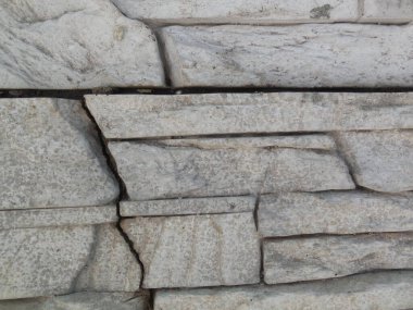 Yapay yüzlü maddenin yardımıyla gri doğal taştan yapılmış duvarcılık taklidi..