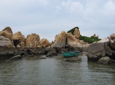 Sıra dışı ve tuhaf şekilli taşlardan oluşan bir ada. Körfezde, geleneksel bir Vietnam yuvarlak teknesi mavi plastikten yapılmış bir sepettir..