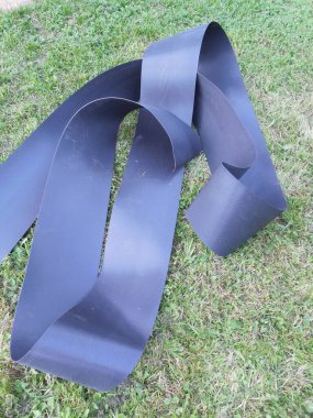 Çiçek yataklarını ve çiçek yataklarını yabani otlardan korumak için siyah esnek sınır bandı. Bahçıvanlığa başlamadan önce sınır çimlere kurulur..