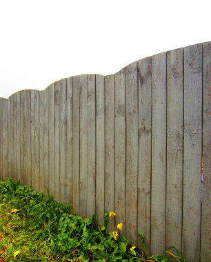 Dalgalı bir üst kenarı olan yüksek, büyük, ahşap bir çit..