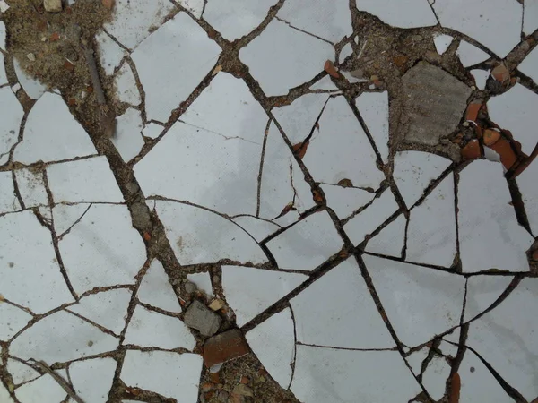 白いセラミックタイルは小さな断片に分割され 地面に横たわって 複雑な明るい抽象的なパターンを形成します — ストック写真