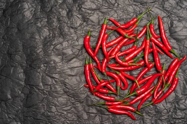 Siyah desenli arka planda farklı kırmızı biberler ve yüksek çözünürlüklü kırmızı biberler.