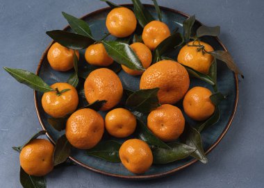 Meyve makro görünümü. Tabakta turuncu mandalina. Citrus masada. Düz yerde yemek tasarımı. Görünür desenli üst görünüm fotoğrafı