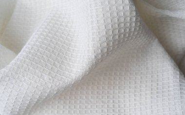 Taze bir mutfak havlusunun dokusu rastgele atılır ve soyut bir şekil alır. Tekstil ev malzemelerinin geçmişi. Üst görünüm waffle havlusu pamuk kumaşı