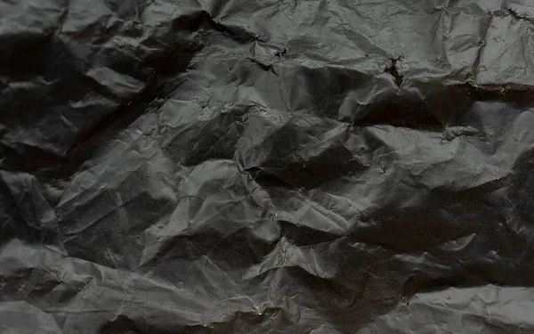 黒のビニール袋の質感と背景 高解像度での段ボールゴミ袋 背景テクスチャ組成物としての砕いた黒ポリエチレンゴミ袋の表面のクローズアップフラグメント — ストック写真
