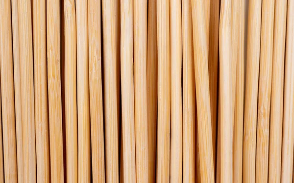 Multiple wooden bamboo skewers laying on white background macro Long wooden skewers for grilling or barbecue background image