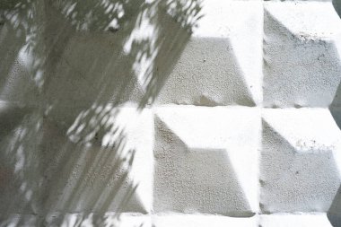 Beton çitin yüzeyinde beyaz renkte boyanmış beton bir piramit var. Taş zemin ve beton çit yıldırımının doku bölümünün detaylarını kapatın.