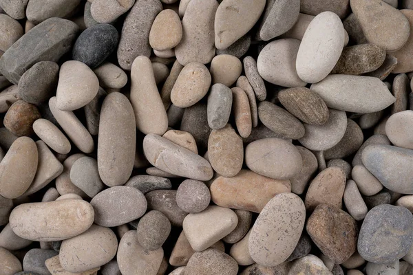Abstract background with pebbles round sea stones sea pebbles and stones, wet, texture, background in high resolution pattern for backdrop Heap of grey dry round stones background, top view
