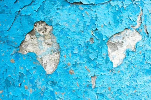 Close up of old stucco cracks on the wall Weathered paint cracks on plaster Cracked blue wall background