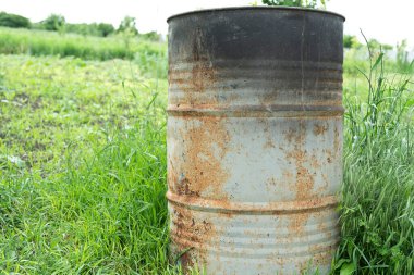 Eski paslı metal fıçıları ve kırsal bir evin arka bahçesinde metal hurdaları yakmak ve çöp öğütücülerini yakmak için bir soba.