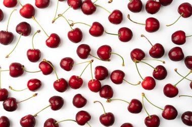 Beyaz arka planda izole edilmiş kiraz meyvesi, beyaz arka planda serpilmiş kırmızı kirazlar, parlak olgun kirazlar.