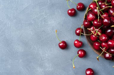 Koyu mavi taşın üstünde taze kirazlı böğürtlenli arka plan.