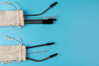 Çeşitli yeniden kullanılabilir paslanmaz çelik pipetler ve mavi arka planda beyaz pamuklu fırçayla temizlik fırçası, yüksek çözünürlüklü çevre dostu yaşam tarzı