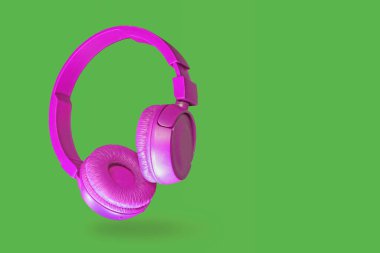 Yeşil arka planda izole edilmiş pembe kulaklıklar.                               