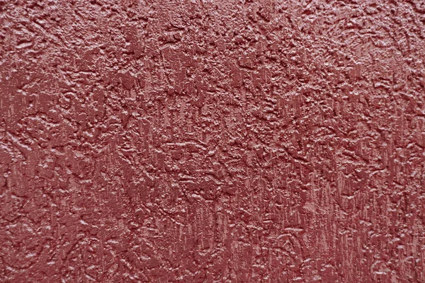 Dark red paint textured wall closeup. Blue background.