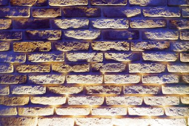 Ortasında ışık lekesi olan tuğla duvar.