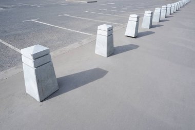 Gri asfaltta beyaz beton yol sütunları