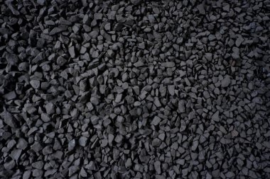 Siyah küçük yol taşı arka planı. Taş çakıl taşları, dikişsiz doku. Ezilmiş granit çakıllarının koyu arkaplanı..