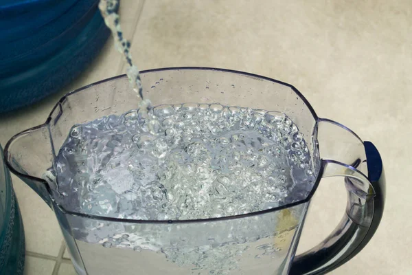 Despeja água fresca no jarro. Fluxos de água fria pura por jato — Fotografia de Stock