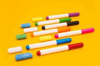 Sarı arka planda çok renkli kalemler ve pastel boyalar. Resim için fotoğraf.
