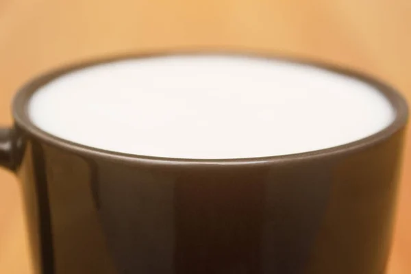 テーブルの上に白い牛乳と黒マグカップ。家での軽い朝食. — ストック写真