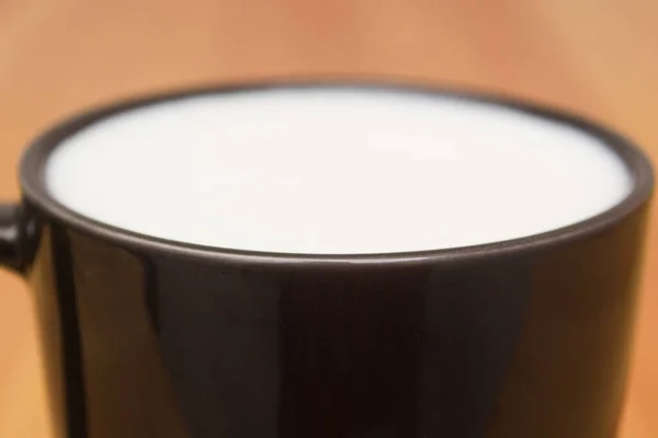 흰 우유가 묻은 검은 머그 컵이요. 집에서의 가벼운 아침 식사. — 스톡 사진