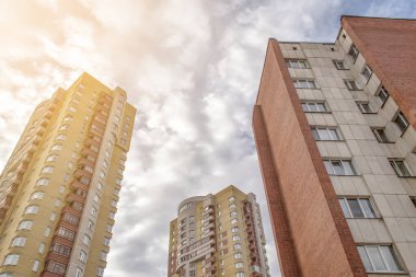 Gökyüzüne ve günbatımına karşı yüksek binalar. Fotoğrafın yanından gelen güneş ışığı.