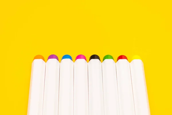 Conjunto de canetas de feltro isoladas em um fundo amarelo em linha — Fotografia de Stock