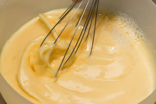 Faire une omelette pour le petit déjeuner. Mélange œufs et lait. — Photo