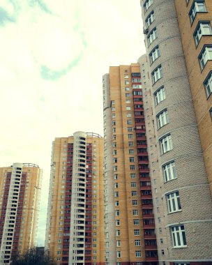 Gün batımında şehir merkezinde, parlak sarı güneş altında güzel yüksek binalar. 